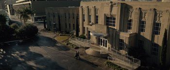 Movie still from “Reminiscence” (2021), directed by Lisa Joy – Two people walking in front of a large building; Extreme Wide shot, Low angle