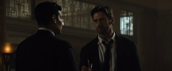 Movie still from “Reminiscence” (2021), directed by Lisa Joy – A man in a suit talking to another man in a suit; Close Up shot, Over the shoulder angle
