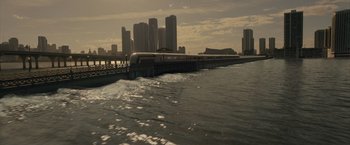 Movie still from “Reminiscence” (2021), directed by Lisa Joy – A train traveling across a body of water near a city skyline; Extreme Wide shot, High angle