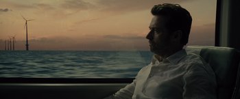 Movie still from “Reminiscence” (2021), directed by Lisa Joy – A man sitting in front of a body of water; Close Up shot, Low angle