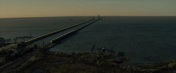 Movie still from “Reminiscence” (2021), directed by Lisa Joy – A view of a body of water with a lighthouse in the distance; Extreme Wide shot, High angle