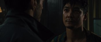 Movie still from “Reminiscence” (2021), directed by Lisa Joy – Two men are standing next to each other in a dark room; Close Up shot, Over the shoulder angle