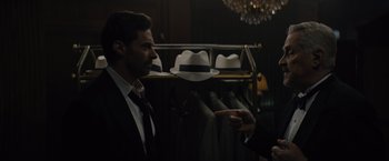 Movie still from “Reminiscence” (2021), directed by Lisa Joy – A man in a suit and tie pointing at a hat; Close Up shot, Over the shoulder angle