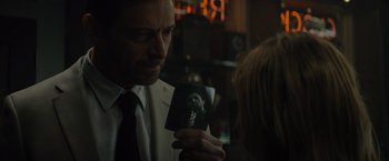 Movie still from “Reminiscence” (2021), directed by Lisa Joy – A man in a white suit holding a photo; Close Up shot, Over the shoulder angle