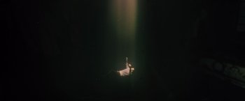 Movie still from “Reminiscence” (2021), directed by Lisa Joy – A person laying on the ground in the dark; Extreme Wide shot, Overhead angle