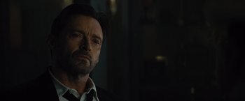 Movie still from “Reminiscence” (2021), directed by Lisa Joy – A person wearing a suit and tie; Close Up shot, Over the shoulder angle