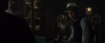 Movie still from “Reminiscence” (2021), directed by Lisa Joy – A man sitting at a table in a room; Close Up shot, Over the shoulder angle