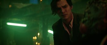 Movie still from “Renfield” (2023), directed by Chris McKay – A man in a suit and tie standing in a dark room; Close Up shot, Low angle