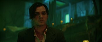 Movie still from “Renfield” (2023), directed by Chris McKay – A person wearing a suit and tie; Close Up shot, Low angle