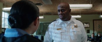 Movie still from “Renfield” (2023), directed by Chris McKay – A man in a uniform talking to a woman; Close Up shot, Over the shoulder angle