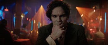 Movie still from “Renfield” (2023), directed by Chris McKay – A man with long hair is holding his hand to his face; Close Up shot, Over the shoulder angle