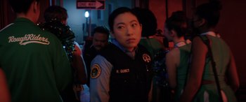 Movie still from “Renfield” (2023), directed by Chris McKay – A woman in a police uniform standing next to a crowd; Close Up shot, Over the shoulder angle