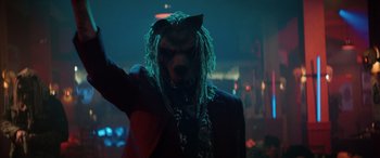 Movie still from “Renfield” (2023), directed by Chris McKay – A person with a mask and a long dread wig; Close Up shot, Low angle