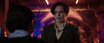 Movie still from “Renfield” (2023), directed by Chris McKay – A man in a suit is looking into the camera; Close Up shot, Over the shoulder angle