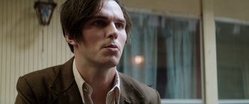 Movie still from “Renfield” (2023), directed by Chris McKay – A person wearing a suit and tie; Close Up shot, Over the shoulder angle