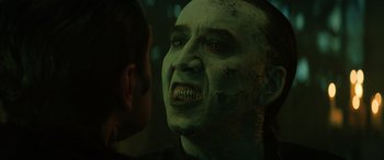 Movie still from “Renfield” (2023), directed by Chris McKay – A person with a green face; Close Up shot, Over the shoulder angle