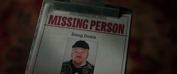 Movie still from “Renfield” (2023), directed by Chris McKay – A missing person poster of a man with a beard; Close Up shot, Overhead angle