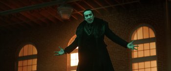 Movie still from “Renfield” (2023), directed by Chris McKay – A man dressed in a black outfit and a black coat; Medium shot, Low angle