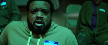 Movie still from “Renfield” (2023), directed by Chris McKay – A person with a name tag; Close Up shot, Over the shoulder angle