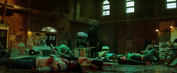 Movie still from “Renfield” (2023), directed by Chris McKay – A group of people laying on the ground in a room; Wide shot, Low angle