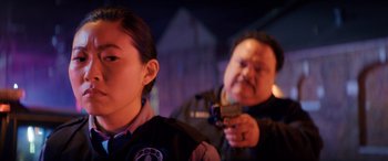 Movie still from “Renfield” (2023), directed by Chris McKay – A man holding a gun in front of a woman; Close Up shot, Over the shoulder angle