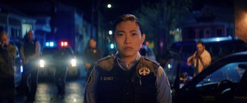 Movie still from “Renfield” (2023), directed by Chris McKay – A police officer standing on the side of the street; Close Up shot, Over the shoulder angle