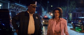 Movie still from “Renfield” (2023), directed by Chris McKay – A police officer standing next to a woman on the street; Medium shot, Over the shoulder angle
