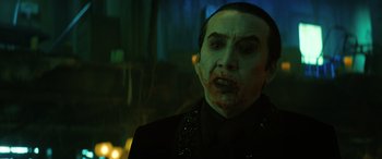 Movie still from “Renfield” (2023), directed by Chris McKay – A person wearing a suit and makeup; Close Up shot, Over the shoulder angle