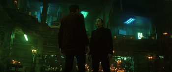 Movie still from “Renfield” (2023), directed by Chris McKay – Two men standing next to each other in front of candles in a dark room; Medium shot, Low angle