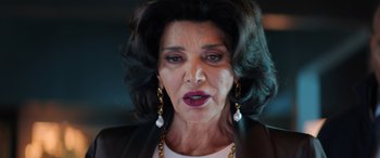 Movie still from “Renfield” (2023), directed by Chris McKay – An older woman wearing a white shirt and a black jacket; Close Up shot, Low angle