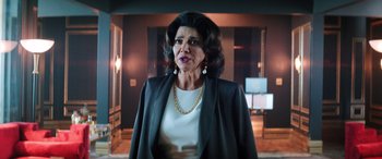 Movie still from “Renfield” (2023), directed by Chris McKay – An older woman wearing a white shirt and a black jacket; Medium shot, Over the shoulder angle