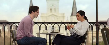 Movie still from “Renfield” (2023), directed by Chris McKay – A man and a woman sitting at an outdoor table; Medium shot, Low angle