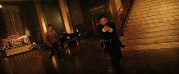 Movie still from “Renfield” (2023), directed by Chris McKay – A woman is taking a picture of herself in a dark room; Wide shot, Low angle