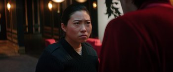 Movie still from “Renfield” (2023), directed by Chris McKay – A woman in a black shirt is looking at the camera; Close Up shot, Over the shoulder angle