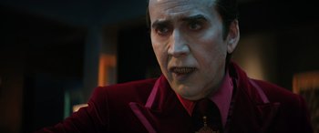 Movie still from “Renfield” (2023), directed by Chris McKay – A person wearing a suit and tie; Close Up shot, Low angle