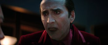 Movie still from “Renfield” (2023), directed by Chris McKay – Nicolas cage in a red shirt and a red tie; Close Up shot, Over the shoulder angle