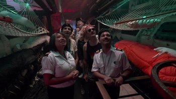 Movie still from “Reno 911!: The Hunt for QAnon” (2021), directed by Robert Ben Garant – A group of people standing in a room; Wide shot, High angle