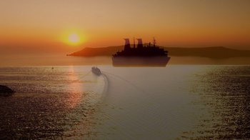 Movie still from “Reno 911!: The Hunt for QAnon” (2021), directed by Robert Ben Garant – A large boat sailing on a body of water at sunset; Extreme Wide shot, Low angle