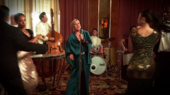 Movie still from “Reno 911!: The Hunt for QAnon” (2021), directed by Robert Ben Garant – A group of people that are singing in a room; Wide shot, Low angle