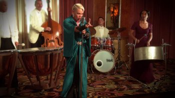 Movie still from “Reno 911!: The Hunt for QAnon” (2021), directed by Robert Ben Garant – A group of people that are performing in a room; Medium shot, Over the shoulder angle