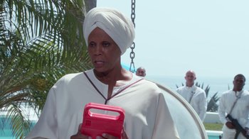 Movie still from “Reno 911!: The Hunt for QAnon” (2021), directed by Robert Ben Garant – A woman in a white robe holding a red object; Close Up shot, Low angle