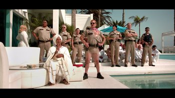 Movie still from “Reno 911!: The Hunt for QAnon” (2021), directed by Robert Ben Garant – A group of men dressed as police officers; Wide shot, Low angle