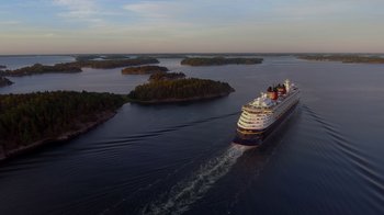 Movie still from “Reno 911!: The Hunt for QAnon” (2021), directed by Robert Ben Garant – A cruise ship sailing on a body of water; Extreme Wide shot, High angle