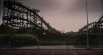 Movie still from “Requiem for a Dream” (2000), directed by Darren Aronofsky – A view of an amusement park from a parking lot; Extreme Wide shot, Low angle