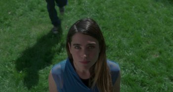 Movie still from “Requiem for a Dream” (2000), directed by Darren Aronofsky – A woman in a blue shirt standing in the grass; Close Up shot, Low angle