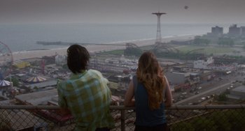 Movie still from “Requiem for a Dream” (2000), directed by Darren Aronofsky – Two people look over a fence at a amusement park; Wide shot, High angle
