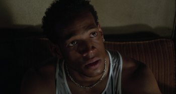 Movie still from “Requiem for a Dream” (2000), directed by Darren Aronofsky – A person wearing a white tank top; Close Up shot, High angle