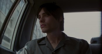 Movie still from “Requiem for a Dream” (2000), directed by Darren Aronofsky – A young man sitting in the passenger seat of a car; Close Up shot, High angle