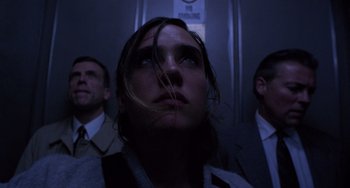 Movie still from “Requiem for a Dream” (2000), directed by Darren Aronofsky – A man with long brown hair is in the dark; Close Up shot, Low angle
