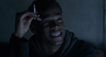 Movie still from “Requiem for a Dream” (2000), directed by Darren Aronofsky – A man smiling while holding a cell phone to his ear; Close Up shot, Low angle
